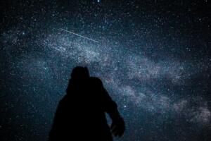 Foto da silhueta de uma pessoa sob um céu noturno bastante estrelado